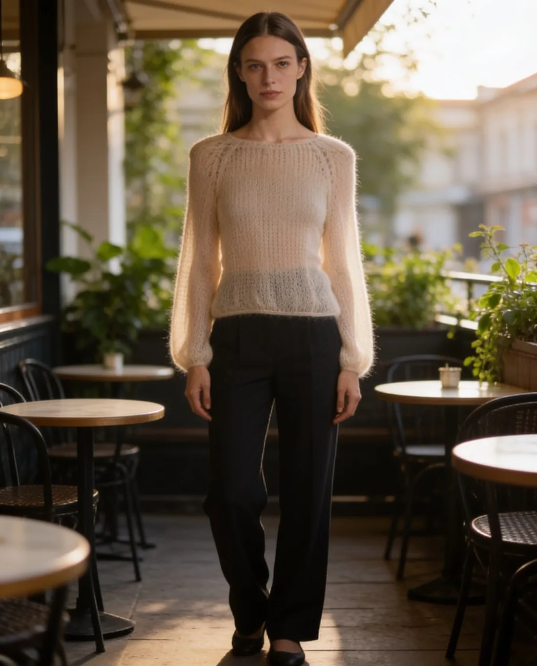 Model i den cremefarvede mohairsweater på en caféterrasse, set i trekvart